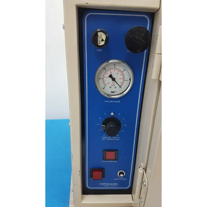 Blue control panel of vwr 1410 scientific vacuum oven with vacuum gauge temperature dial and red push buttons