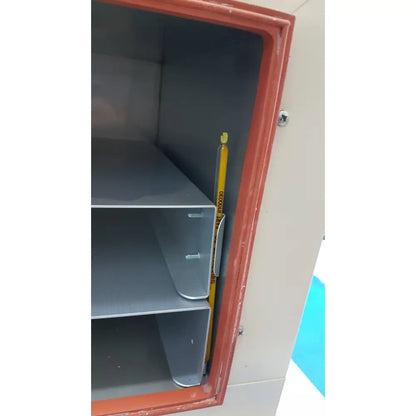 A yellow measuring tape with black text and bright yellow tip resting vertically inside an open vwr 1410 scientific vacuum oven cabinet