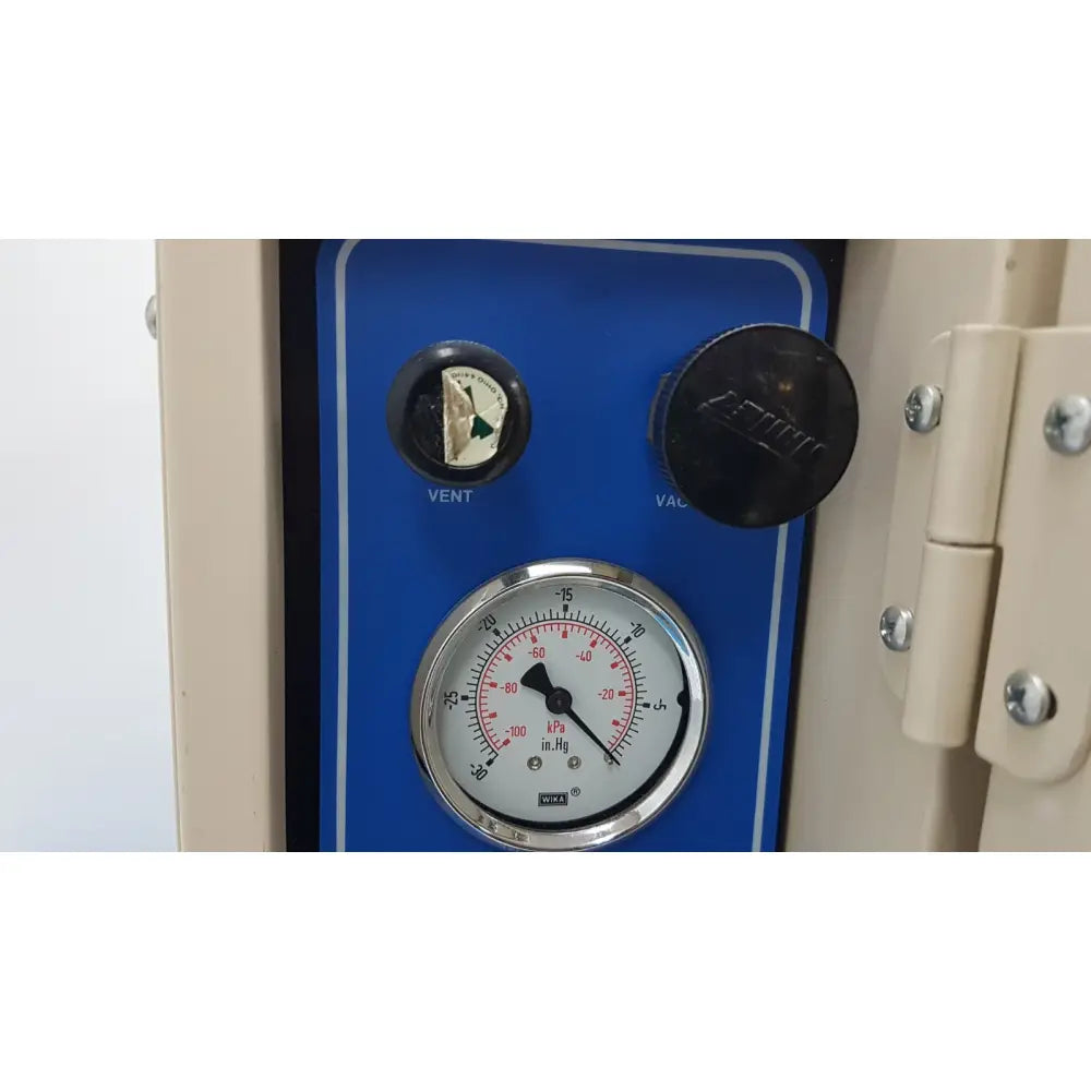 Blue control panel of vwr 1410 scientific vacuum oven with circular pressure gauge and black knobs for vent and vac functions