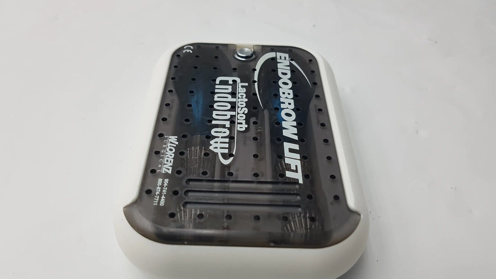 White and black lorenz surgical endobrow lift kit device with perforated top surface and molded plastic casing