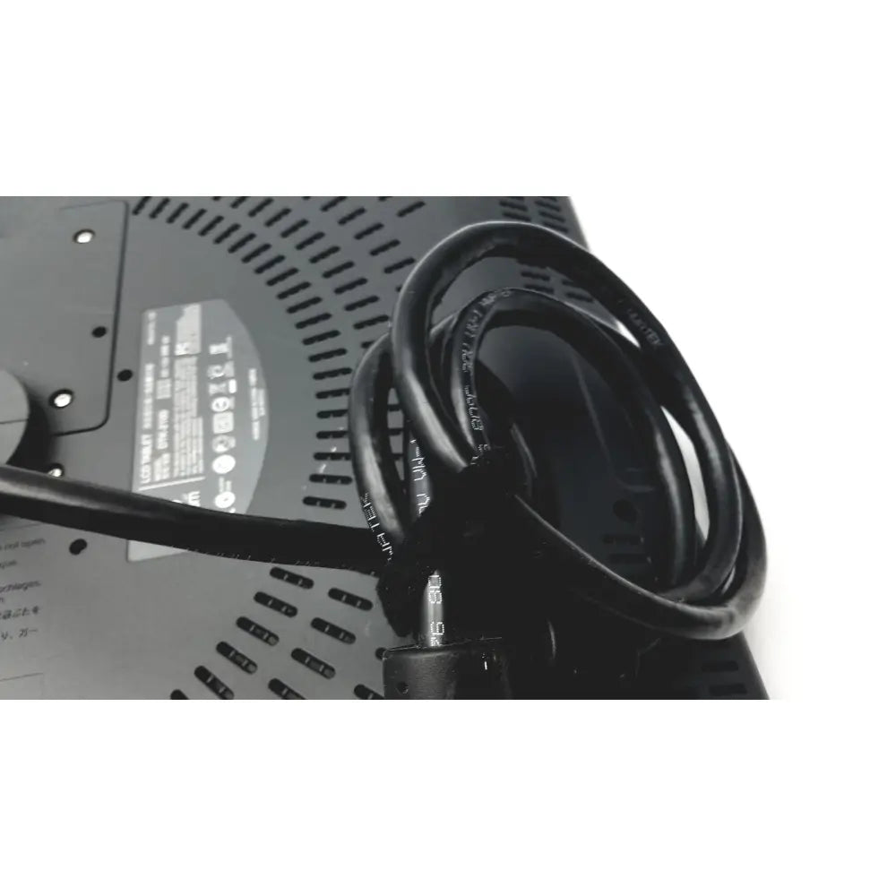 Black coiled power cord with printed specifications wrapped around the back of a wacom cintiq 21ux graphics monitor