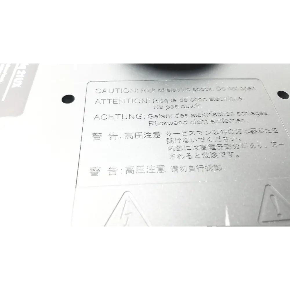 White plastic warning label with multilingual safety cautions on the back of wacom cintiq 21ux graphics monitor