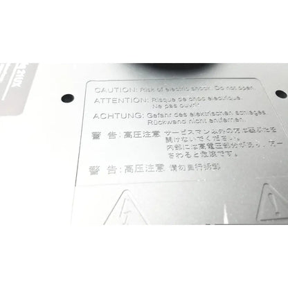 White plastic warning label with multilingual safety cautions on the back of wacom cintiq 21ux graphics monitor