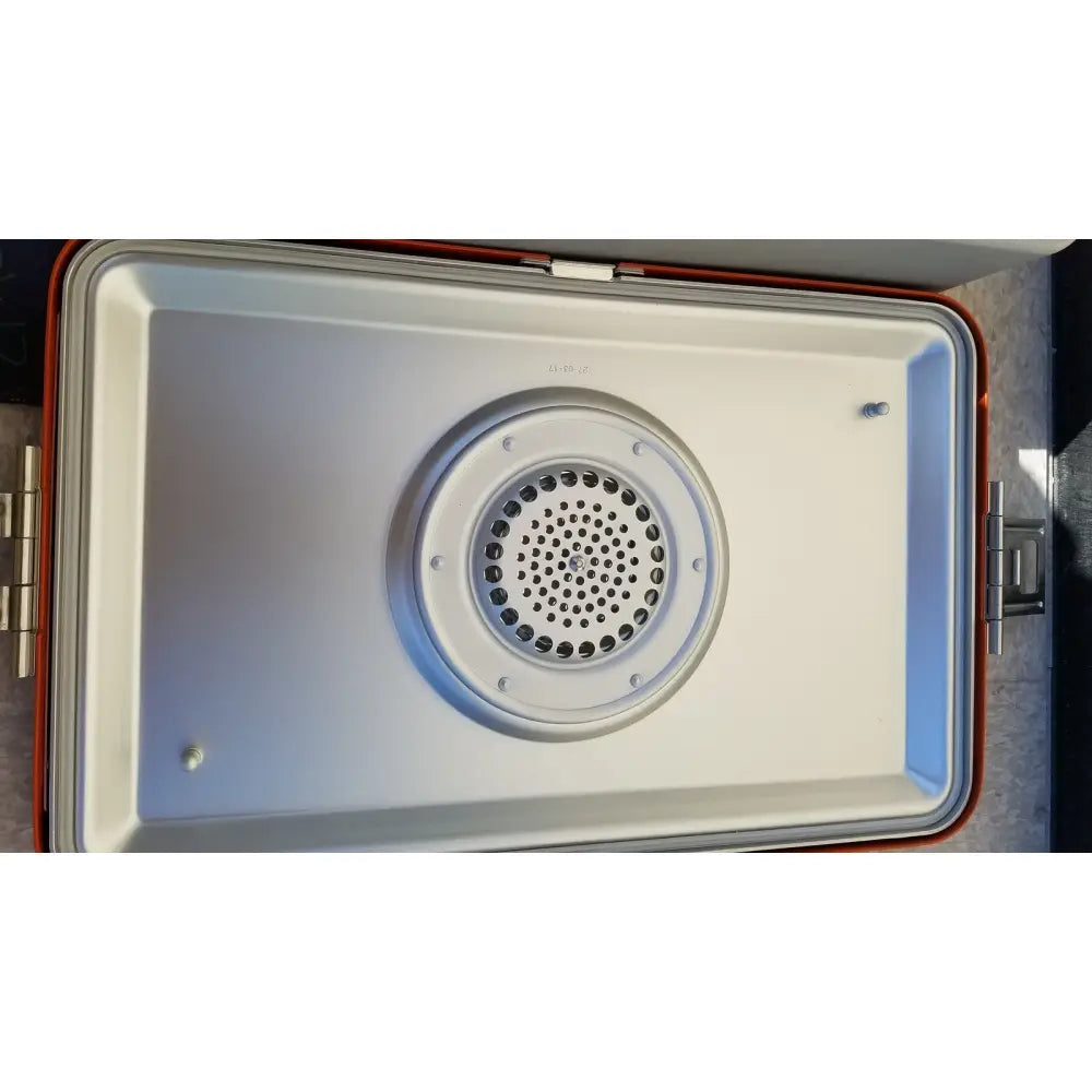 The interior of a red and white portable speaker with a circular perforated grille in wagner steriset storage container