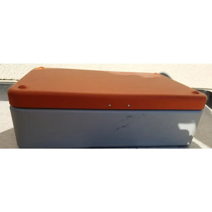 Orange and gray plastic Wagner Steriset storage box with rounded corners and small screws along the top edge for sterilization