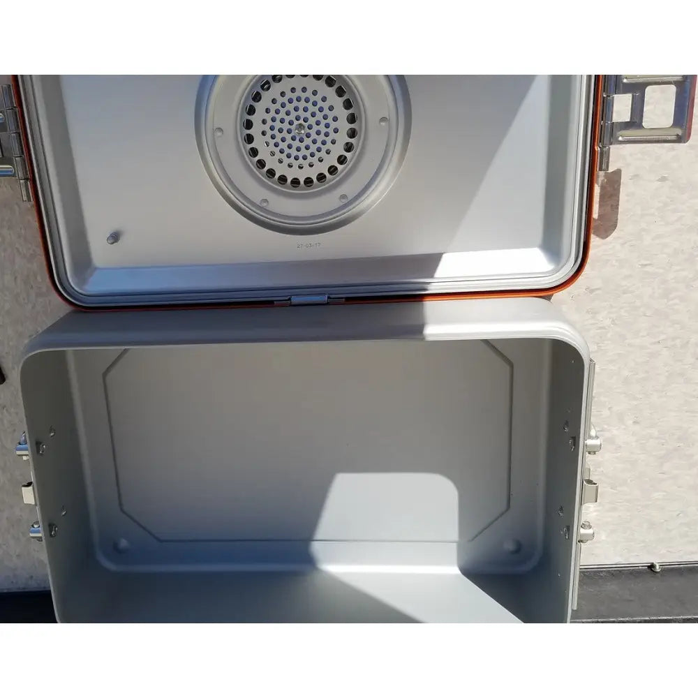 Silver and orange portable camping stove with perforated burner in wagner steriset storage sterilization container