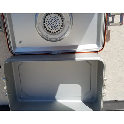 Silver and orange portable camping stove with perforated burner in wagner steriset storage sterilization container