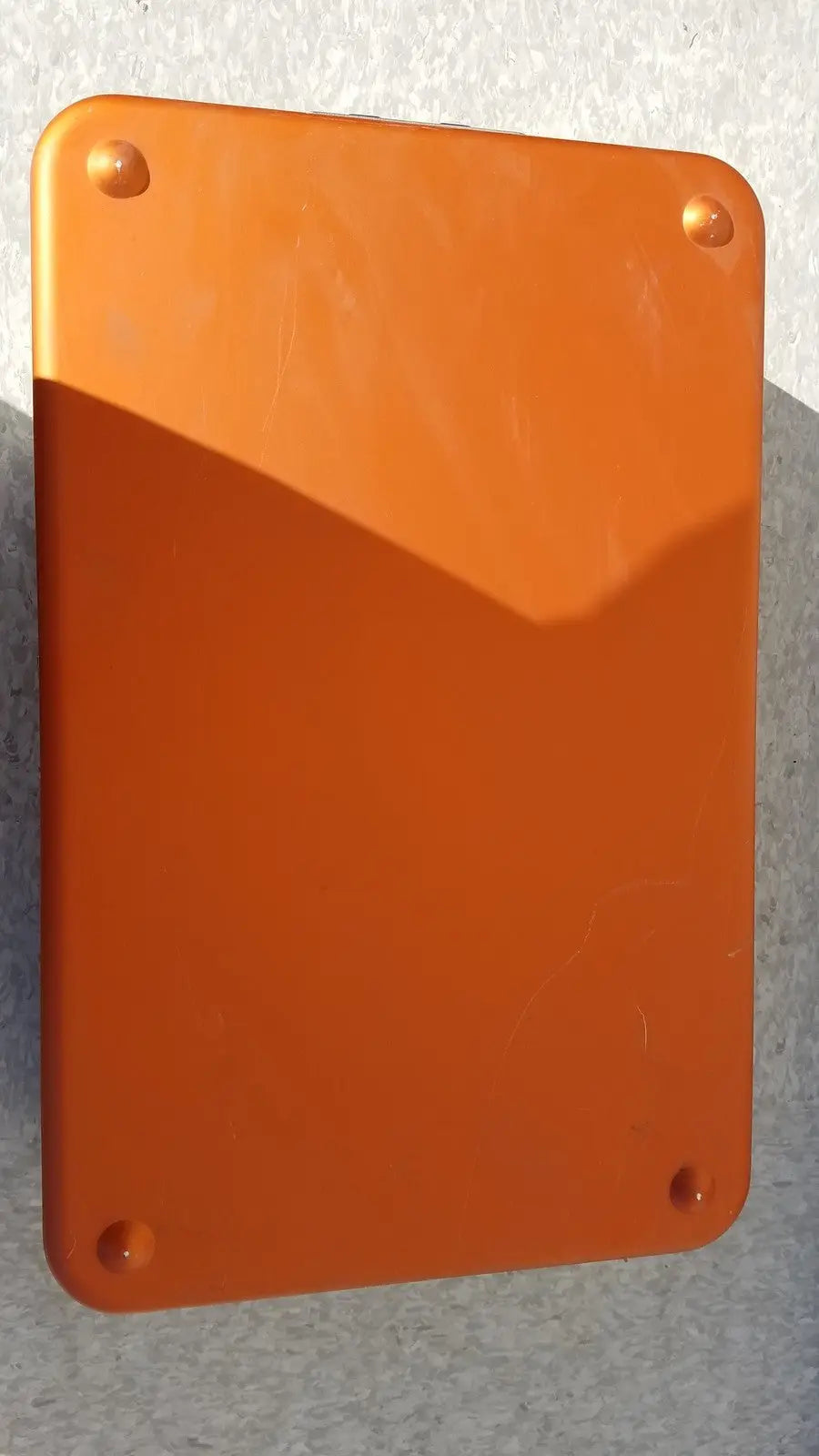 Orange rectangular plaque with rounded corners and four fasteners on wagner steriset storage container