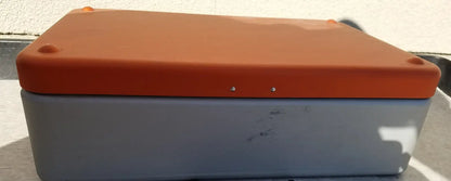 Orange and gray plastic Wagner Steriset storage box with rounded corners and small screws along the top edge for sterilization