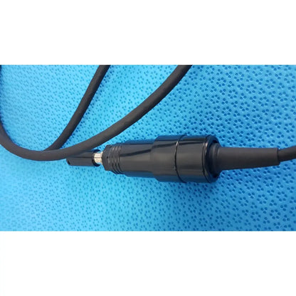 Black cylindrical Welch Allyn illuminator bulb cable with metallic silver tip attached to black bulb cable cord