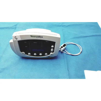White Welch Allyn 300 series vital signs monitor with digital display control buttons and attached sensor cable for vital signs monitoring