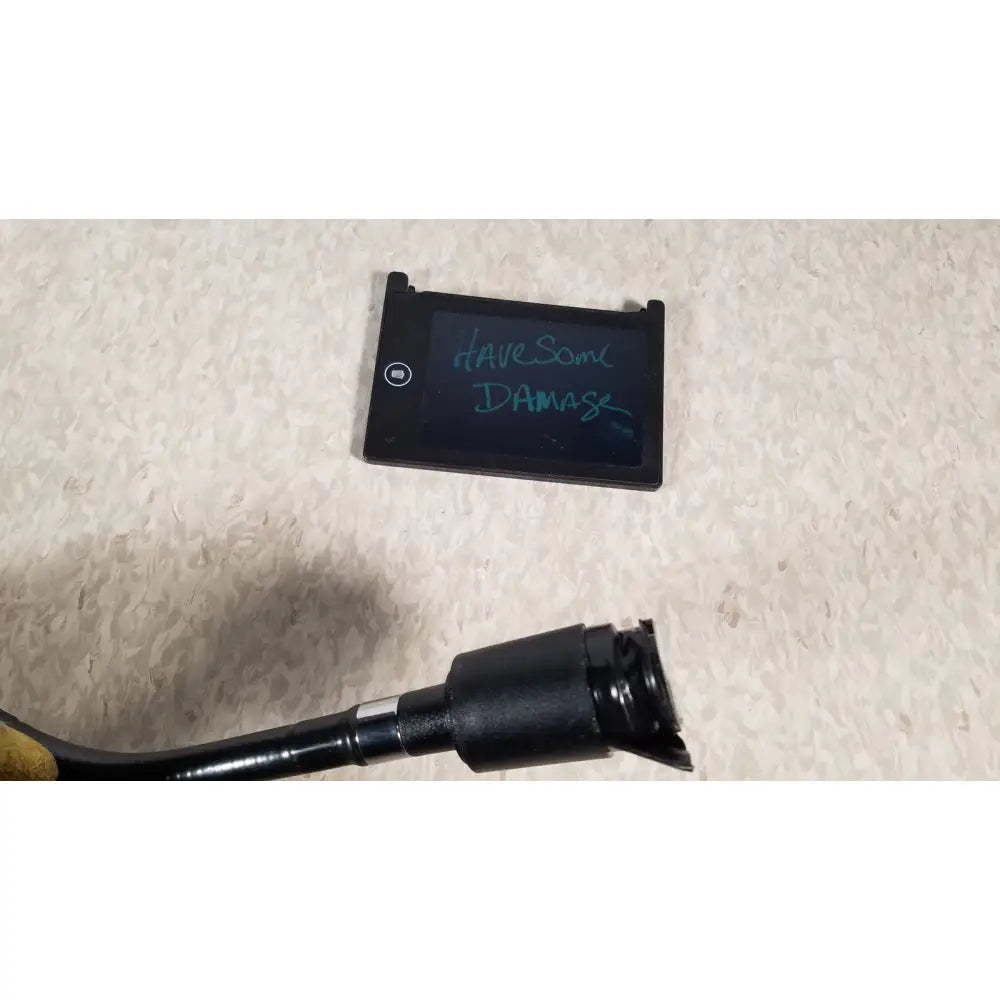 Black rectangular welch allyn fiberoptic light pipe with a small screen showing teal handwritten text for medical exams