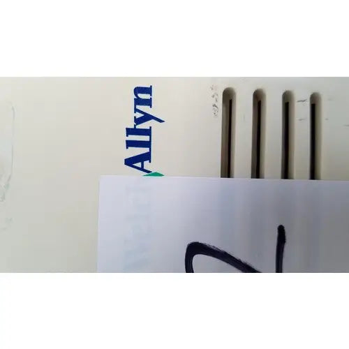 White paper with handwritten text partially covering the welch allyn 48740 exam light electronic device details