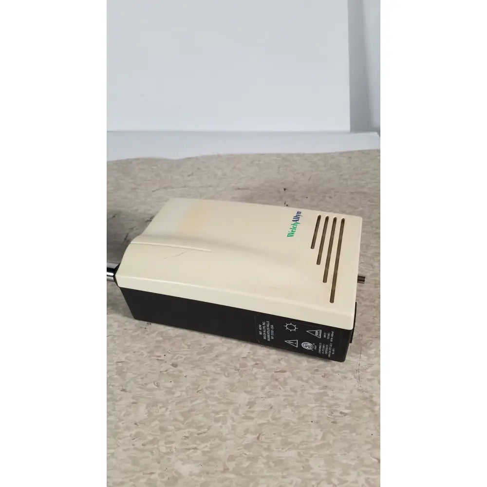 Beige and black weathermaster tankless water heater with vertical vent slits and welch allyn 48740 exam light neck