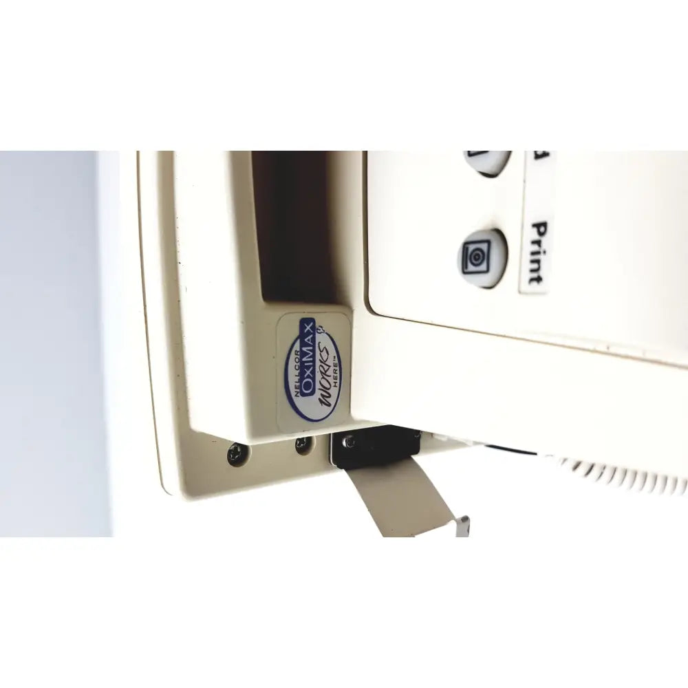 White plastic oximax mores label with blue and black text on beige printer side panel of welch allyn vital signs monitor