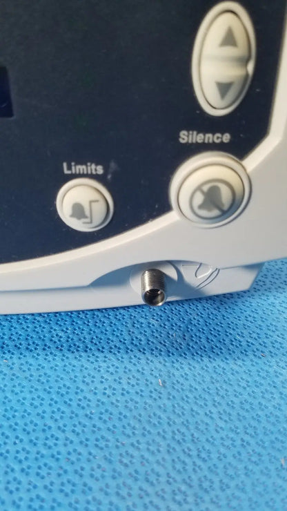 White and dark gray welch allyn 530t0 vital signs monitor with circular limits and silence buttons and a small metallic port below