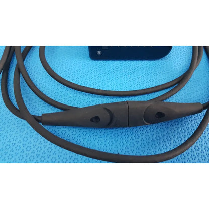 Black silicone-coated welch allyn power adapter plug with central control module and two circular buttons for medical devices