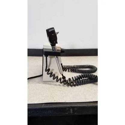 Black and silver welch allyn 74710 transformer diagnostic scope with coiled cord mounted on a white stand