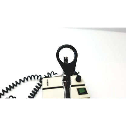 Black handheld welch allyn transformer ophthalmoscope otoscope with chrome handle and coiled cable beside beige base unit