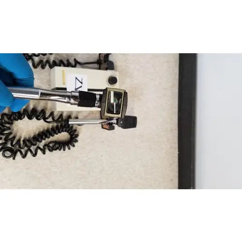 Welch allyn 74710 wall transformer with a silver-toned otoscope, black rubber grip, and coiled black cable for reuse medical use