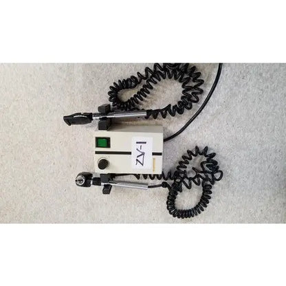 Beige welch allyn 74710 wall transformer with black coiled cords and green power indicator light for reuse medical devices