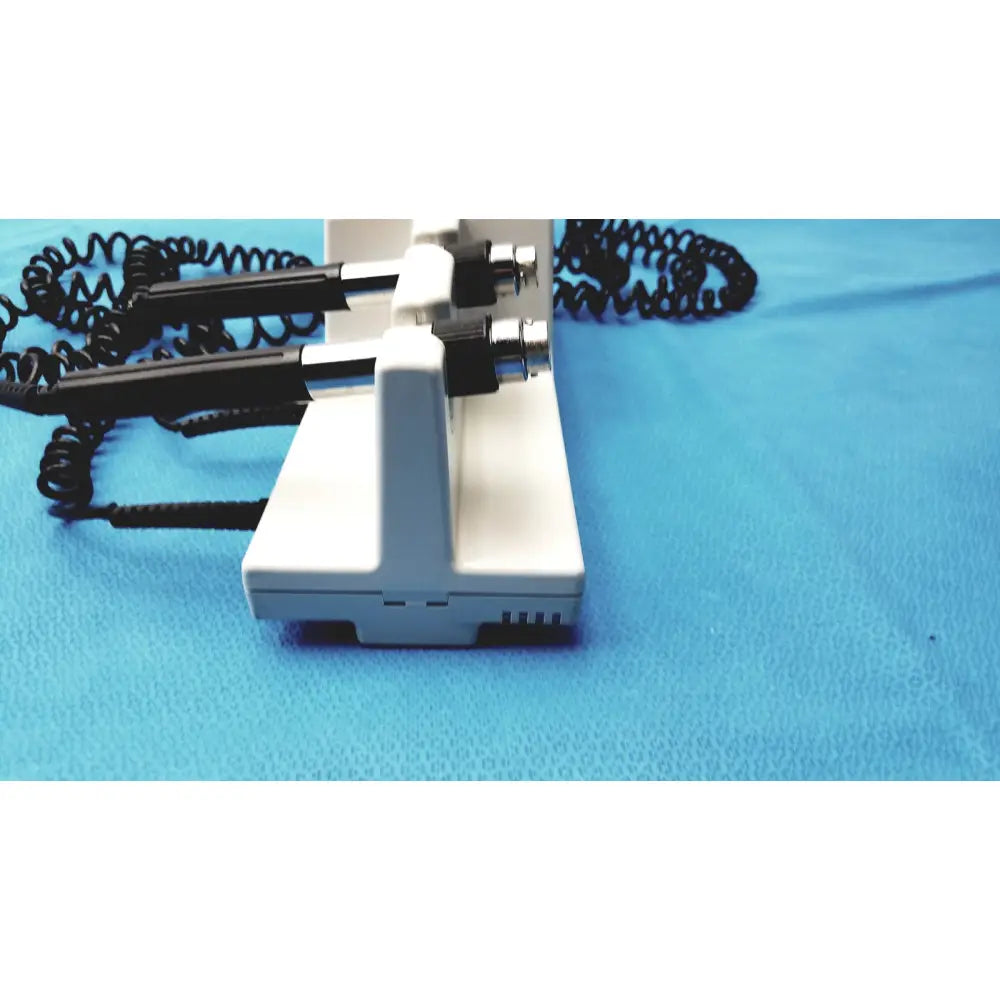 Welch Allyn integrated wall diagnostic system with white otoscope, black handles, and coiled cords for medical use