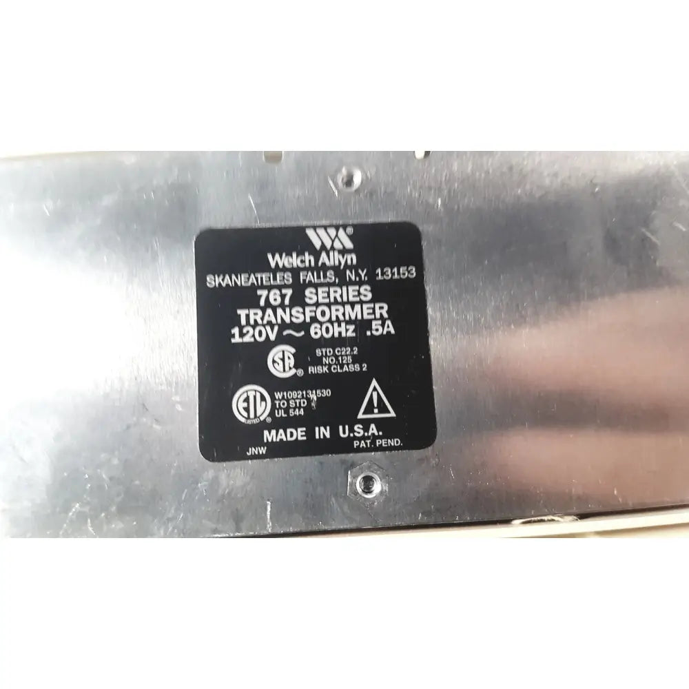 Black rectangular label on the back of welch allyn 767 series transformer showing white text and diagnostic wall transformer details
