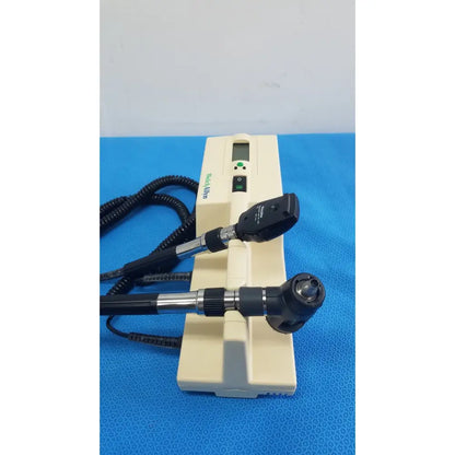 Beige hoya alpha ophthalmoscope with black and silver arms digital display and coiled cables in welch allyn series transformer for reuse medical use
