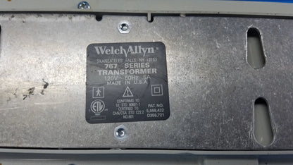 Black rectangular label on metallic surface showing welch allyn 767 series transformer for wall-mounted diagnostic power without instrument heads
