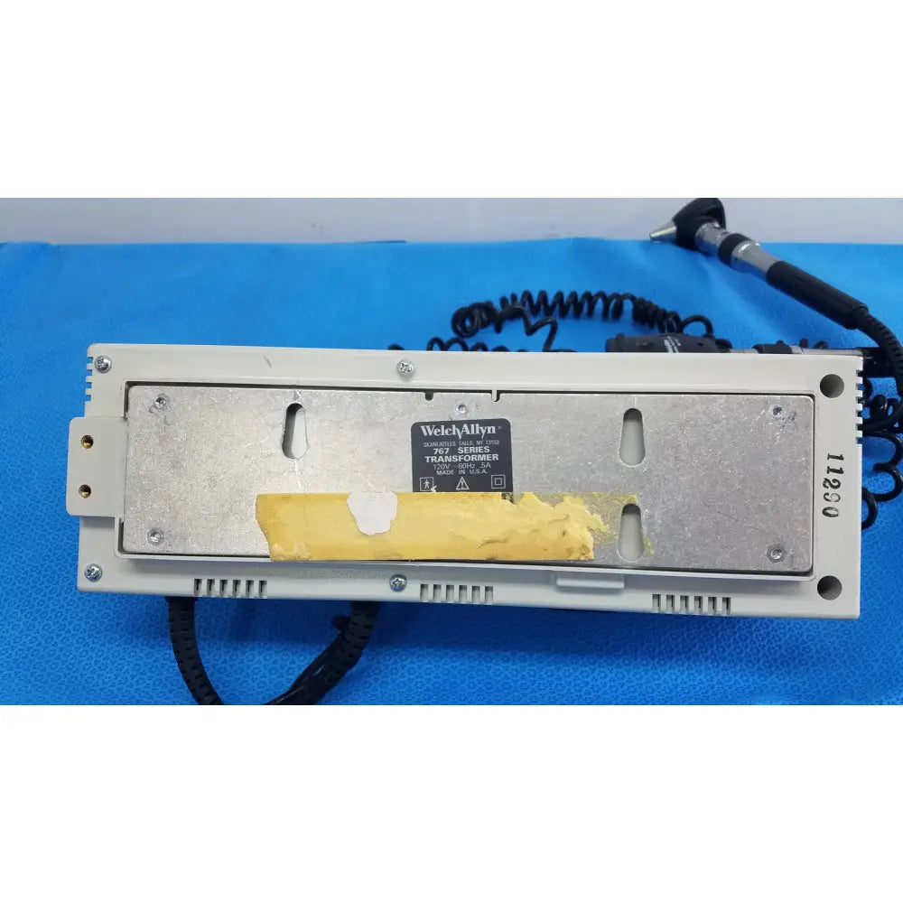 Beige welch allyn 103 series wall transformer with metallic backplate and yellow tape on label for ophthalmoscope use