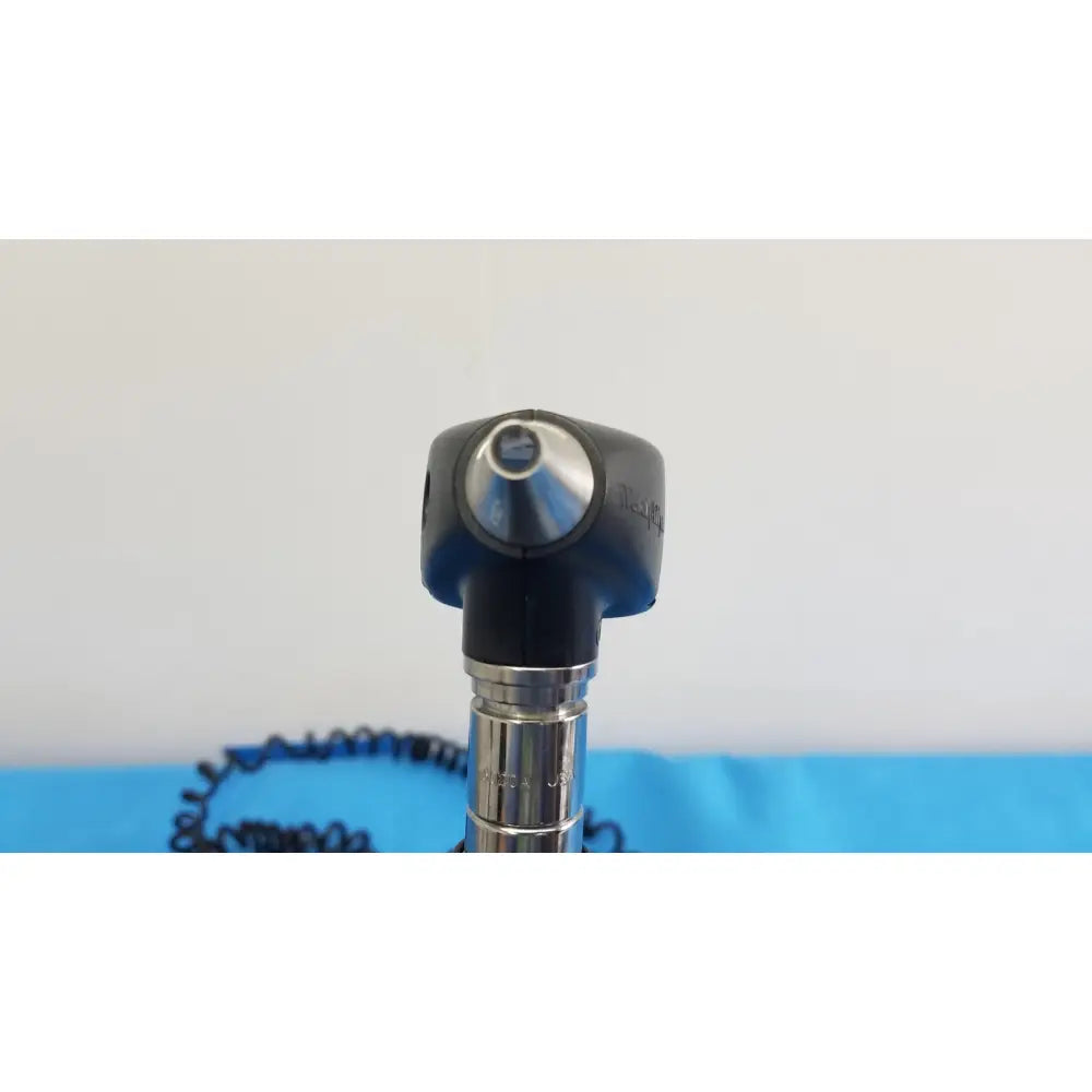 Black and silver otoscope with rounded head metallic shaft and coiled cable from welch allyn 767 series wall transformer