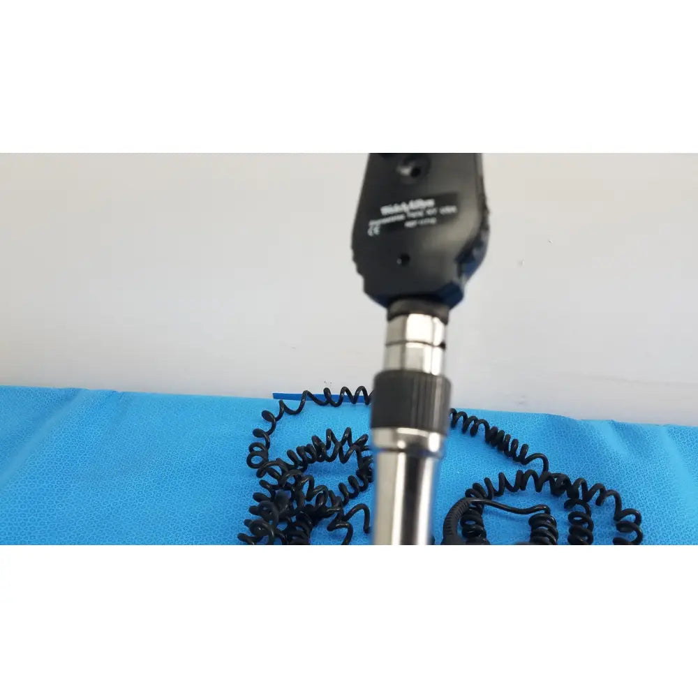 Black and silver handheld ophthalmoscope with coiled black cable from welch allyn 767 series wall transformer product