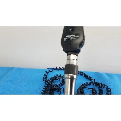 Black and silver handheld ophthalmoscope with coiled black cable from welch allyn 767 series wall transformer product