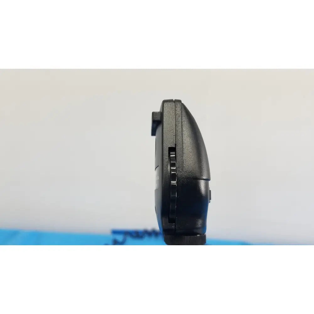 Black plastic handheld gaming device with textured grip and buttons shown with welch allyn 767 series wall transformer