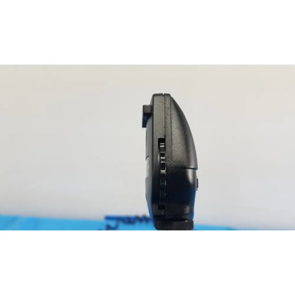 Black plastic handheld gaming device with textured grip and buttons shown with welch allyn 767 series wall transformer