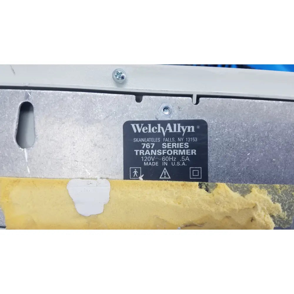 Welch allyn 767 series wall transformer with black label, silver metallic casing, and yellow protective tape at bottom