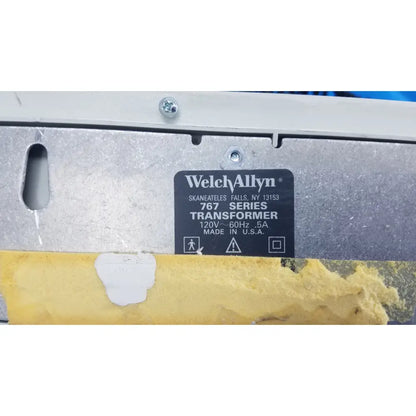 Welch allyn 767 series wall transformer with black label, silver metallic casing, and yellow protective tape at bottom