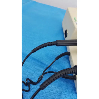 Black coiled cables with ribbed protective sleeves connected to the back of a beige welch allyn 767 series wall transformer