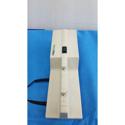 White plastic welch allyn 767 series wall transformer with green wetaalpin branding and black power switch