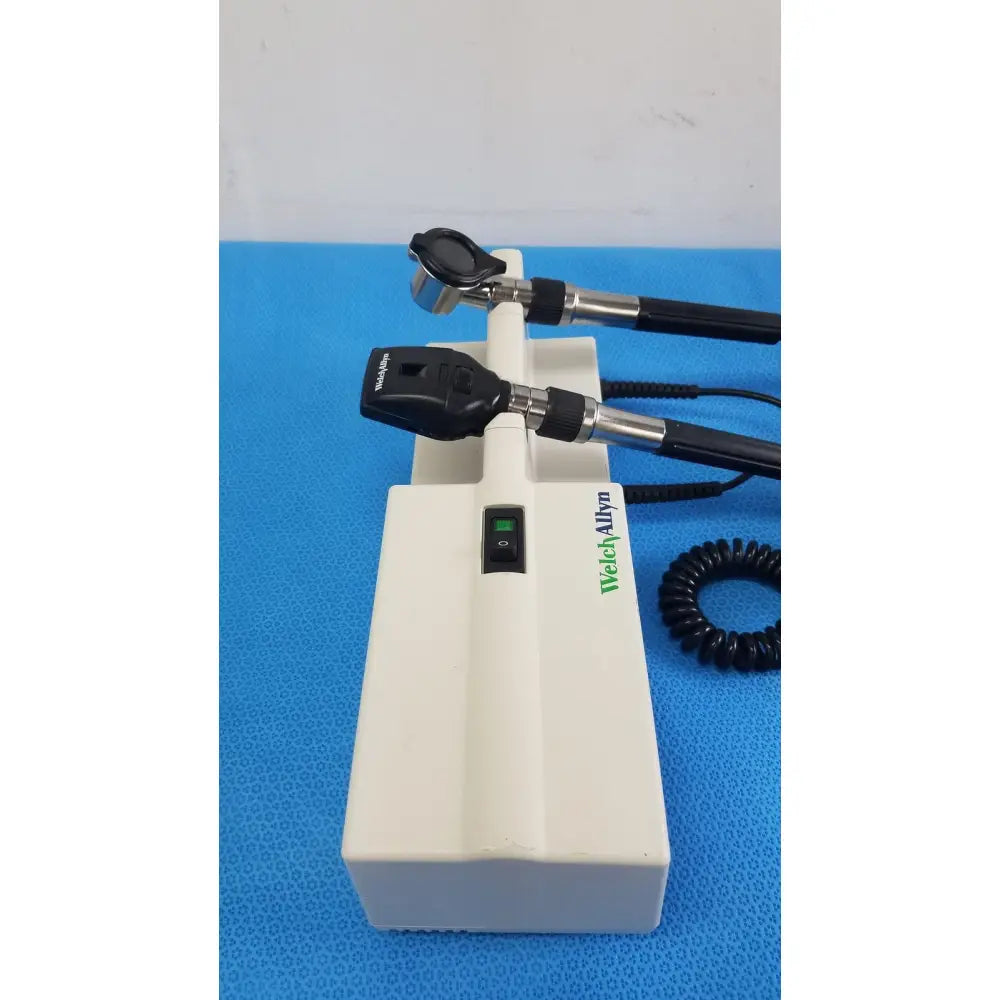 Welch Allyn white plastic wall transformer base with two black and silver reuse medical otoscope heads