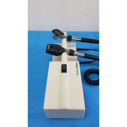 Welch Allyn white plastic wall transformer base with two black and silver reuse medical otoscope heads