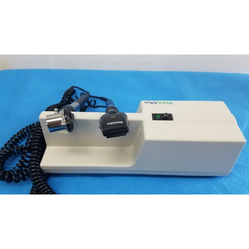 White rectangular Welch Allyn wall transformer with black coiled cables and coaxial ophthalmoscope metallic probe attachment