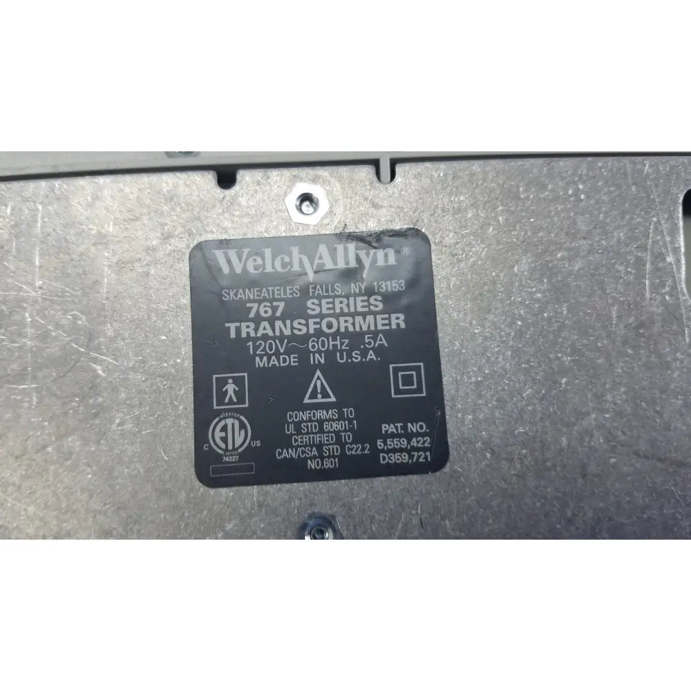 Black rectangular label on metallic surface identifies welch allyn 767 wall transformer for reuse medical devices