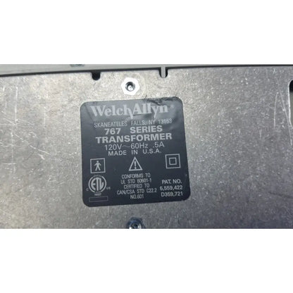 Black rectangular label on metallic surface identifies welch allyn 767 wall transformer for reuse medical devices