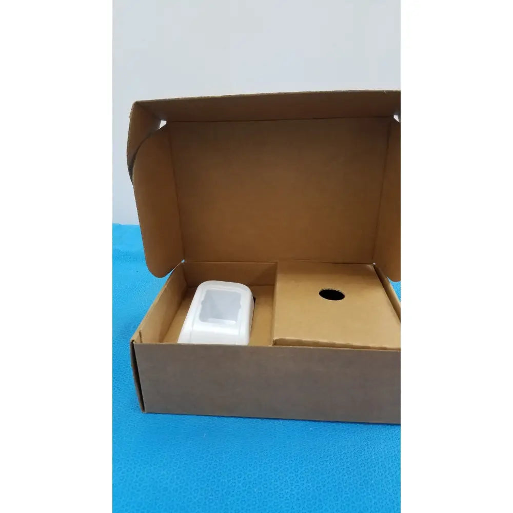Welch Allyn kleenspec cordless led white plastic device with rounded edges inside an open cardboard box