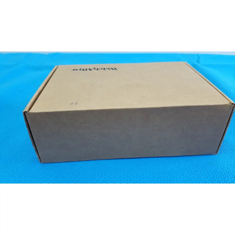 A plain brown cardboard box with vigilant branding containing the welch allyn kleenspec cordless led illumination system