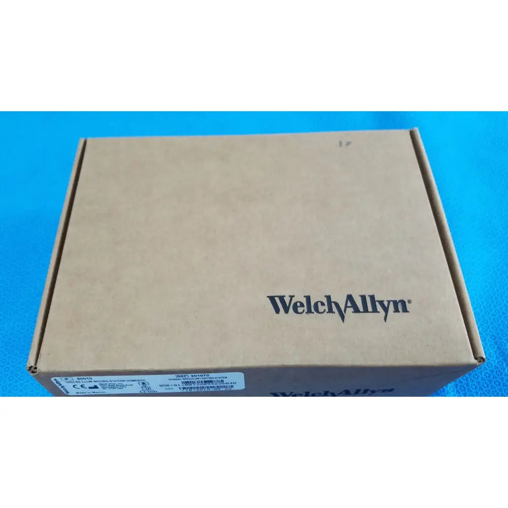Brown cardboard box with welch allyn printed in black containing kleenspec cordless led illumination system and charger
