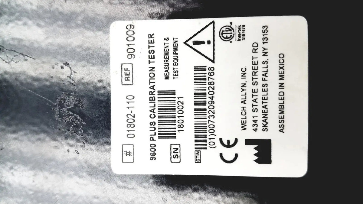 White rectangular label on welch allyn 9600 plus calibration tester showing model number serial number and certification marks