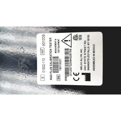 White rectangular label on welch allyn 9600 plus calibration tester showing model number serial number and certification marks