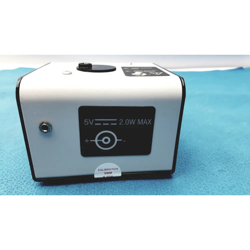 White rectangular welch allyn 9600 plus calibration tester with black trim and calibration void if seal sticker on back side